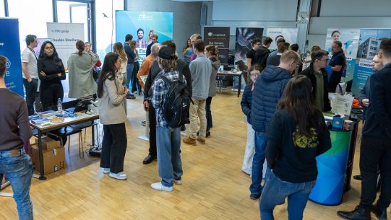 Bild vom Hochschulinfotag mit Studieninteressierten, die sich an den Ausstellerständen über das duale Studium erkundigen